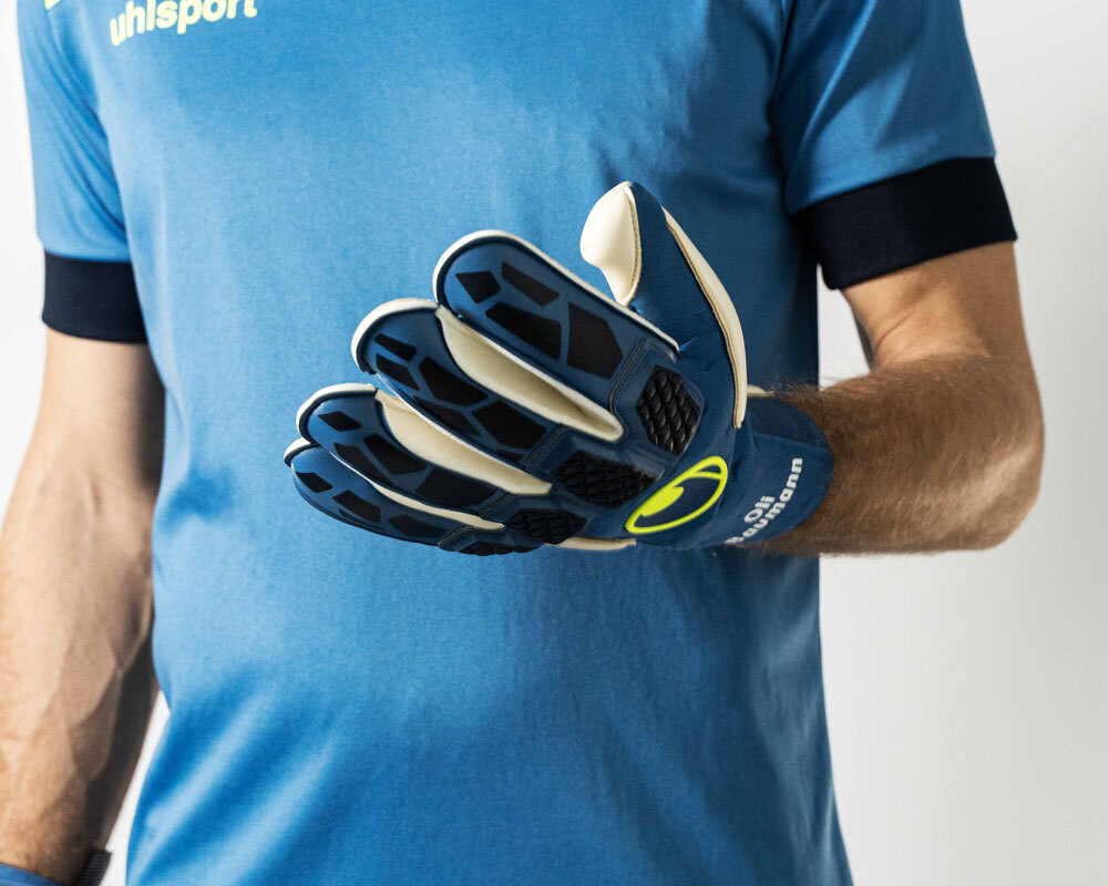 Mann im blauen T-Shirt mit uhlsport Torwarthandschuhem